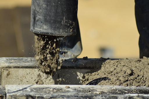 Concrete being poured through a pipe.