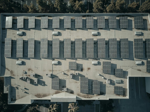 A row of roof-mounted solar panels on the top of a building.