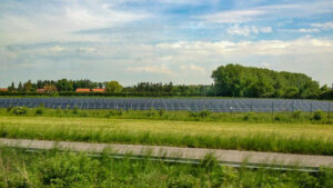 Several solar panels set amidst green fields