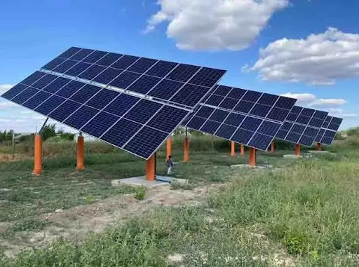 Solar panels mounted on poles in a field, utilizing a single-axis ground mount tracking system for optimal sunlight exposure.