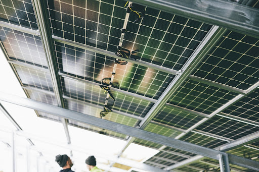 Technicians inspecting a ground-mount solar panel